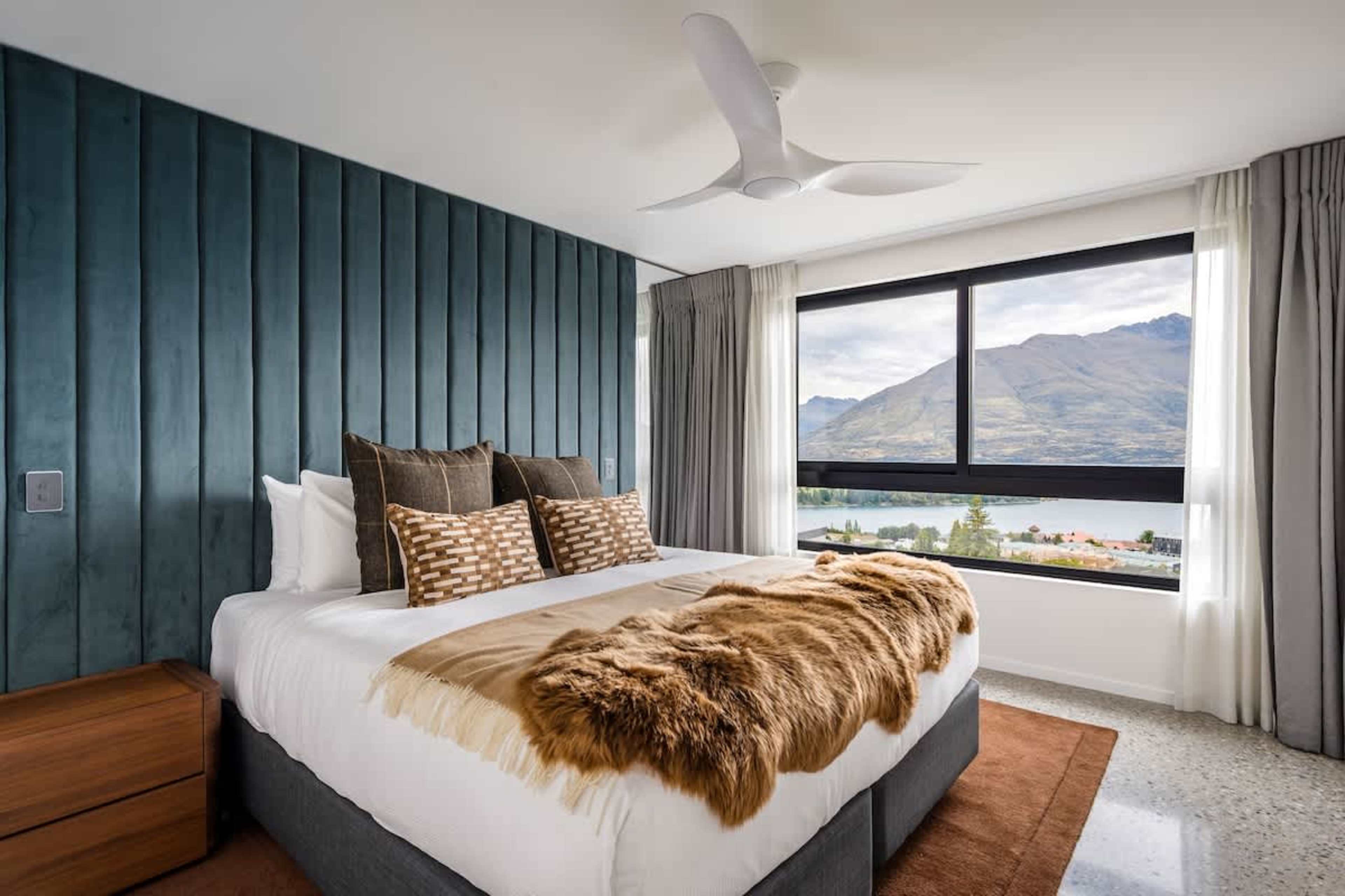 Private ensuite comfort
Bedroom 3 offers a peaceful retreat with a modern private ensuite and plush bedding. Large windows frame the stunning lake and mountain views, creating a serene escape.