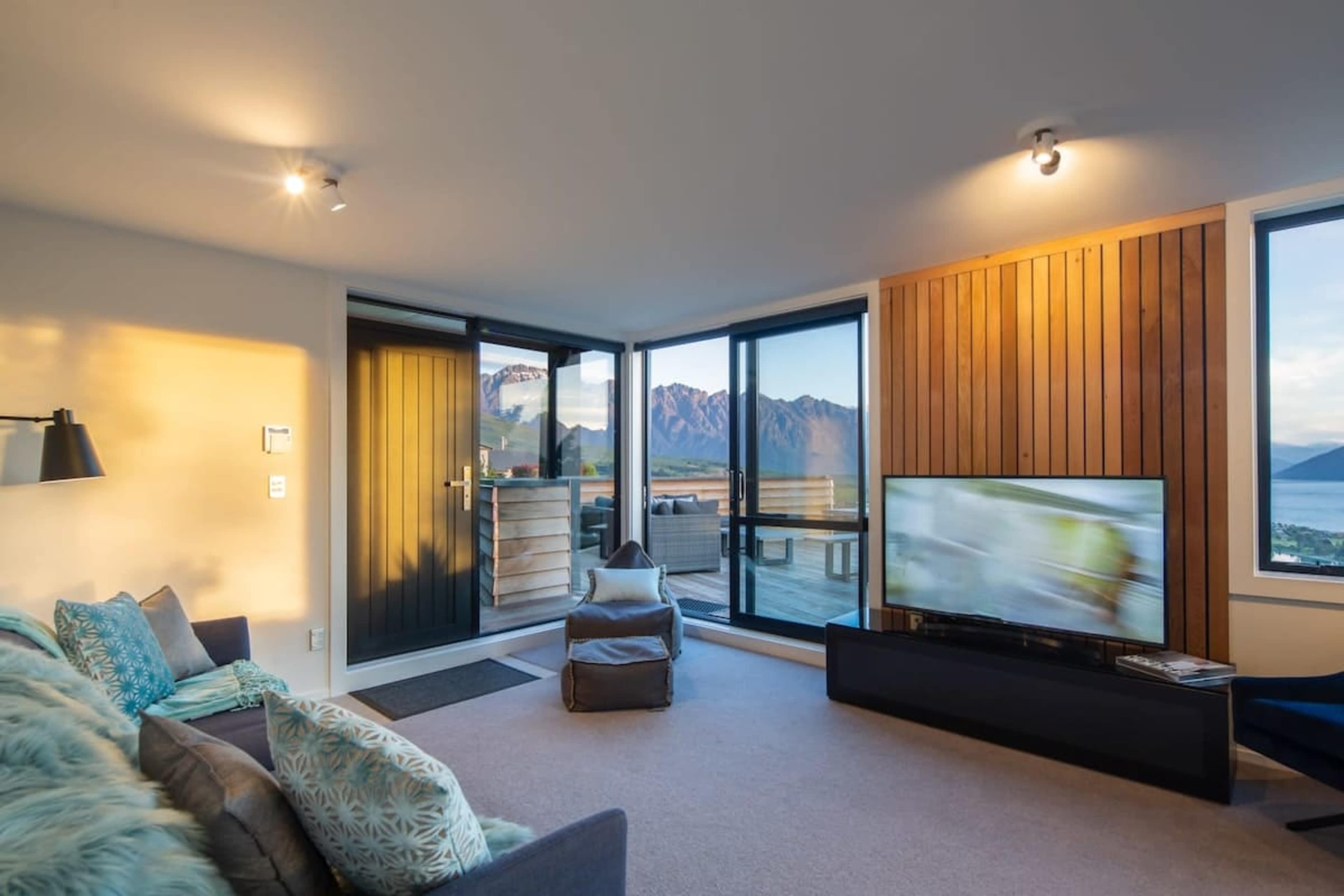 Spacious Living Room with Lake and Mountain Views – Unwind in this inviting living area, complete with large windows that frame breathtaking views of Lake Wakatipu and the Remarkables, offering a serene and scenic atmosphere for relaxation.