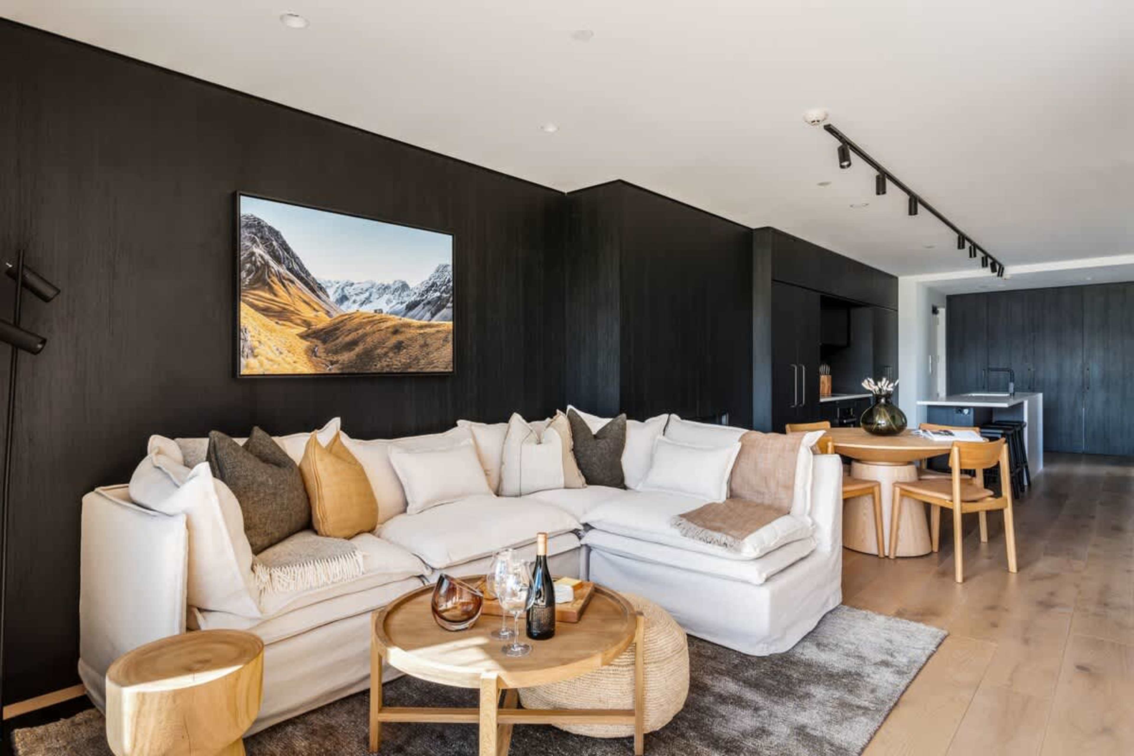 Stunning living area in Clubhouse Lane apartments, Jacks Point. Breathtaking mountain & lake views over golf course, contemporary alpine interior, oak flooring, high cedar ceilings, cozy fireplace, wall of glass. Perfect Queenstown getaway.