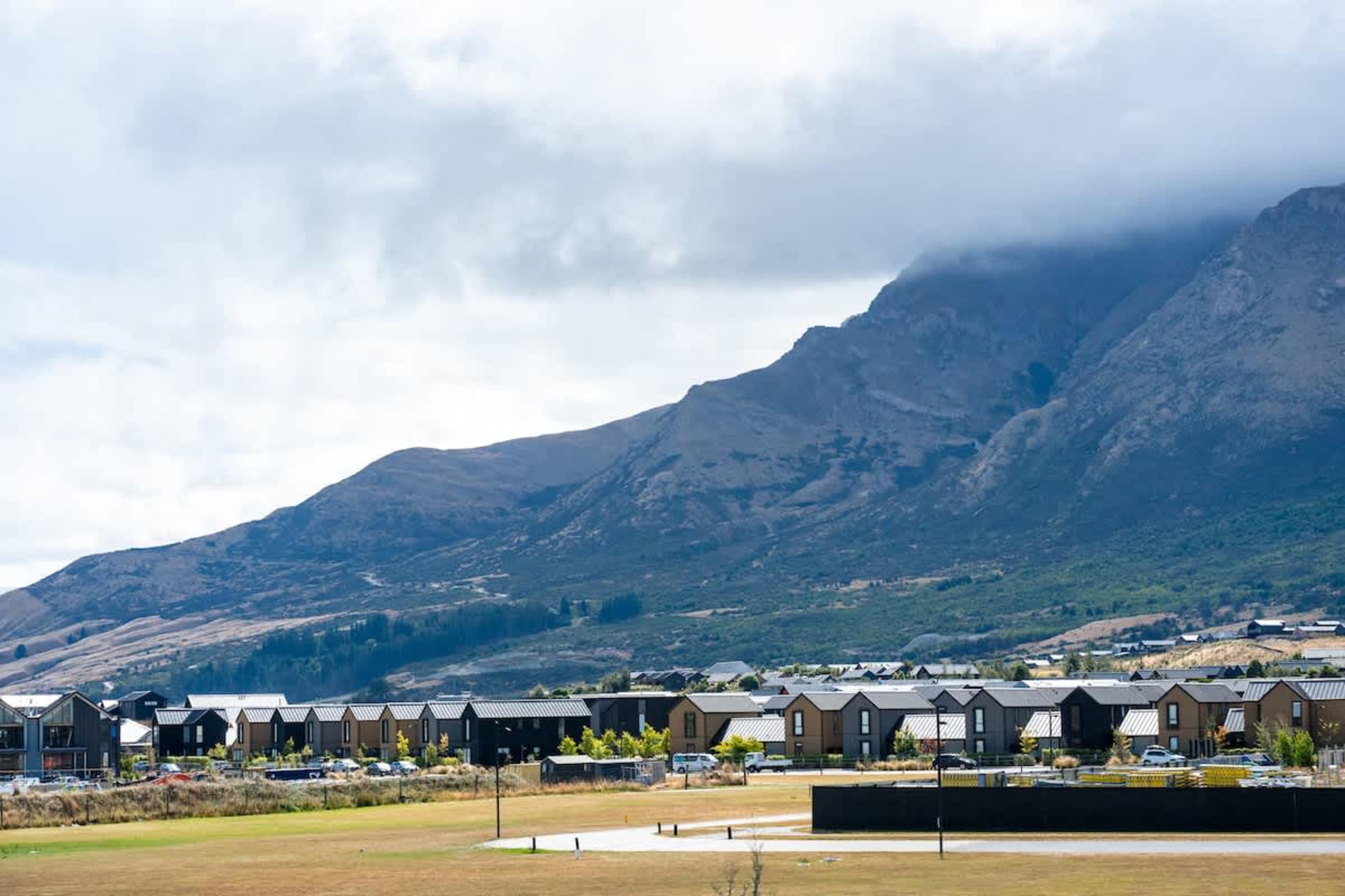 Exterior of Clubhouse Lane apartments, Jacks Point Golf Course. Elegant modern alpine building with uninterrupted Remarkables & Lake Tewa views across the fairways. Golf & ski escape.