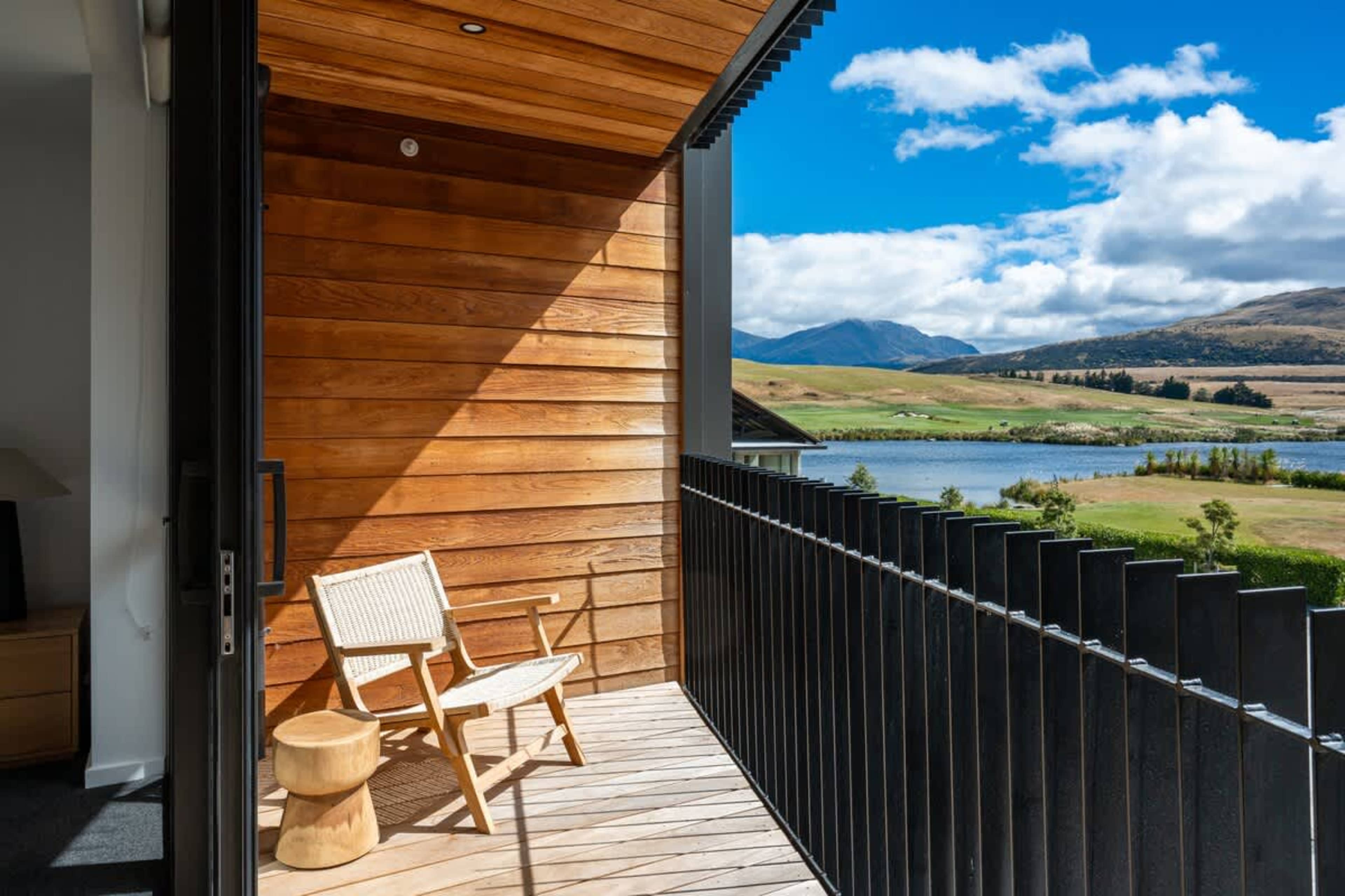 Private deck with panoramic views, Clubhouse Lane apartments, Jacks Point Golf Course. Stunning Remarkables mountains & Lake Tewa over the golf course, modern outdoor lounge, perfect for sunrise coffee. Queenstown golf & ski retreat.