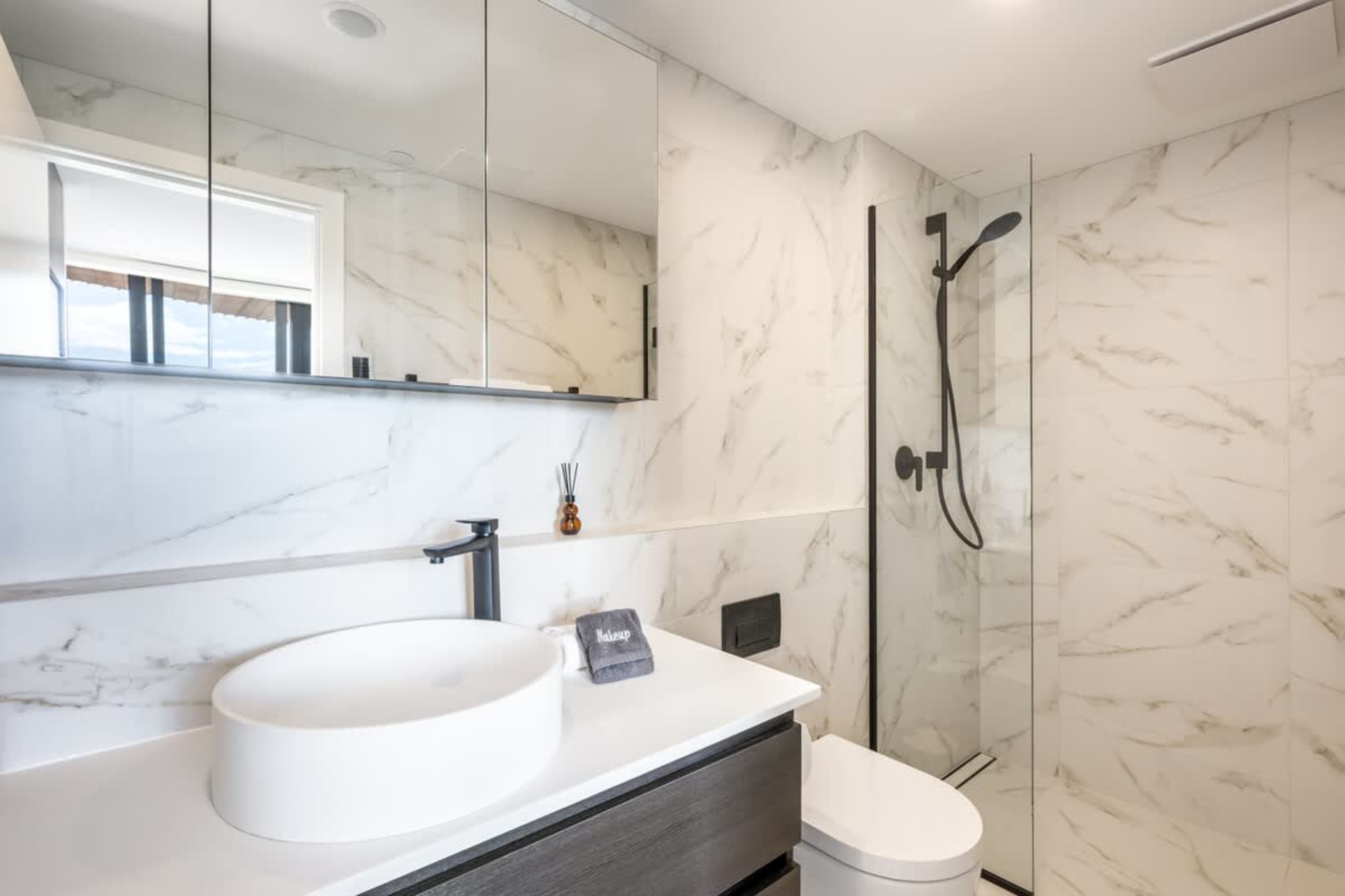 Luxury master ensuite bathroom, Clubhouse Lane apartments, Jacks Point Golf Course. Heated tile floors, double vanity, walk-in shower, modern alpine design, premium amenities. Queenstown golf & ski retreat.