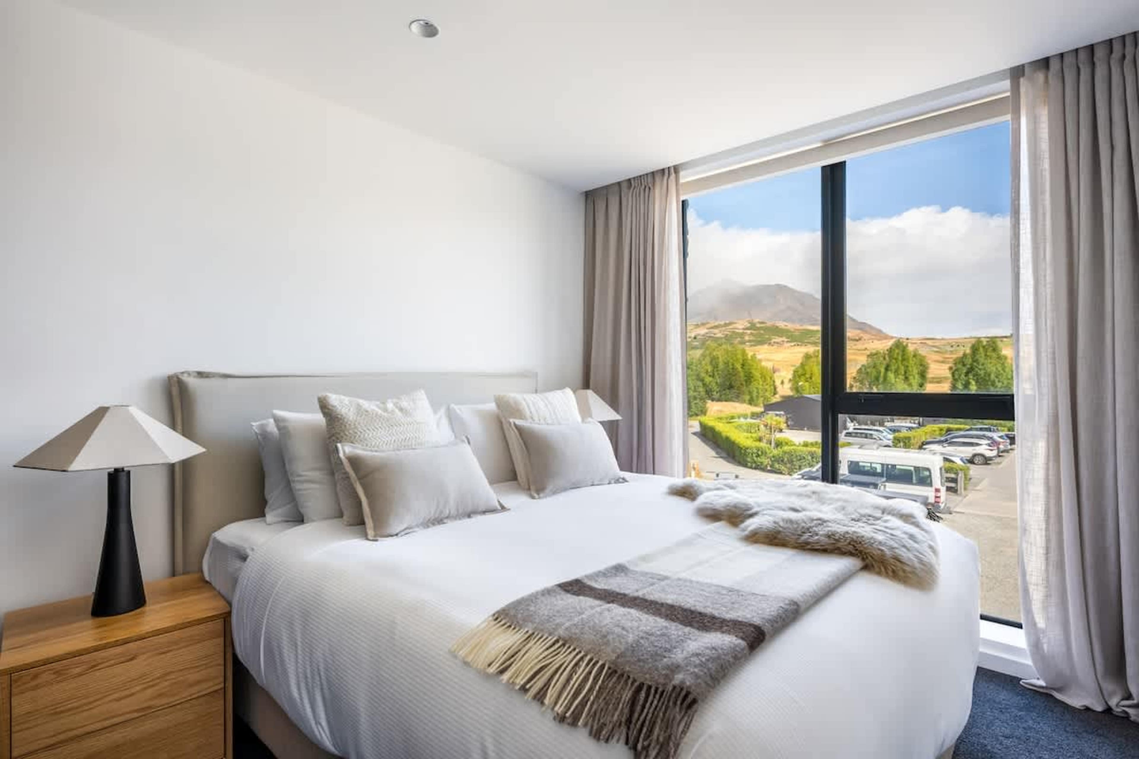 Spacious Bedroom 3 at Clubhouse Lane, Jacks Point. King Sleepyhead bed convertible to two singles, luxurious bedding and pillows, cozy modern alpine design. Perfect Queenstown golf course family escape.