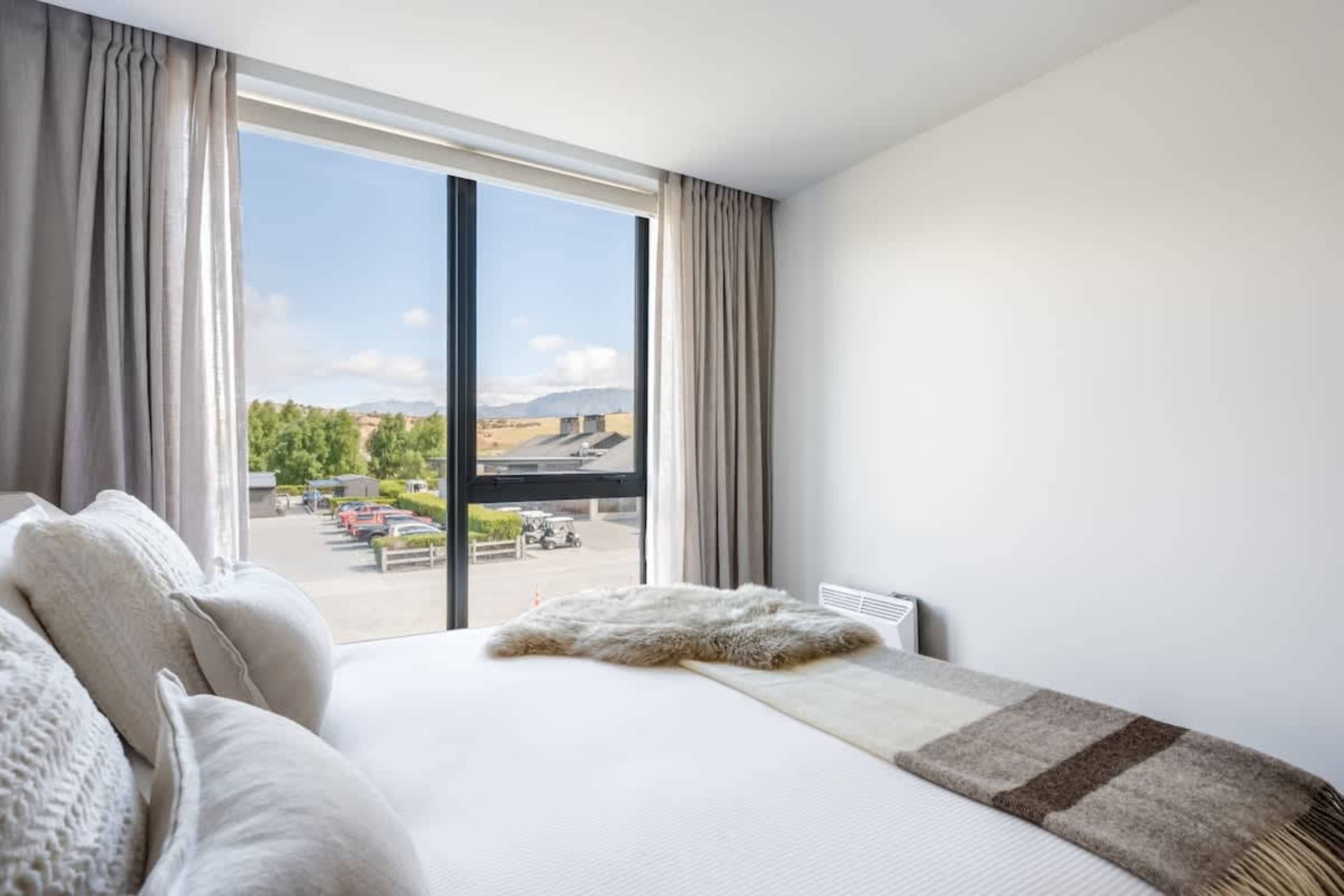 Bedroom 3, Clubhouse Lane apartments, Jacks Point Golf Course. Flexible king Sleepyhead bed that splits into two singles, premium plush bedding, modern alpine style, high-quality linens. Queenstown golf & ski family retreat.