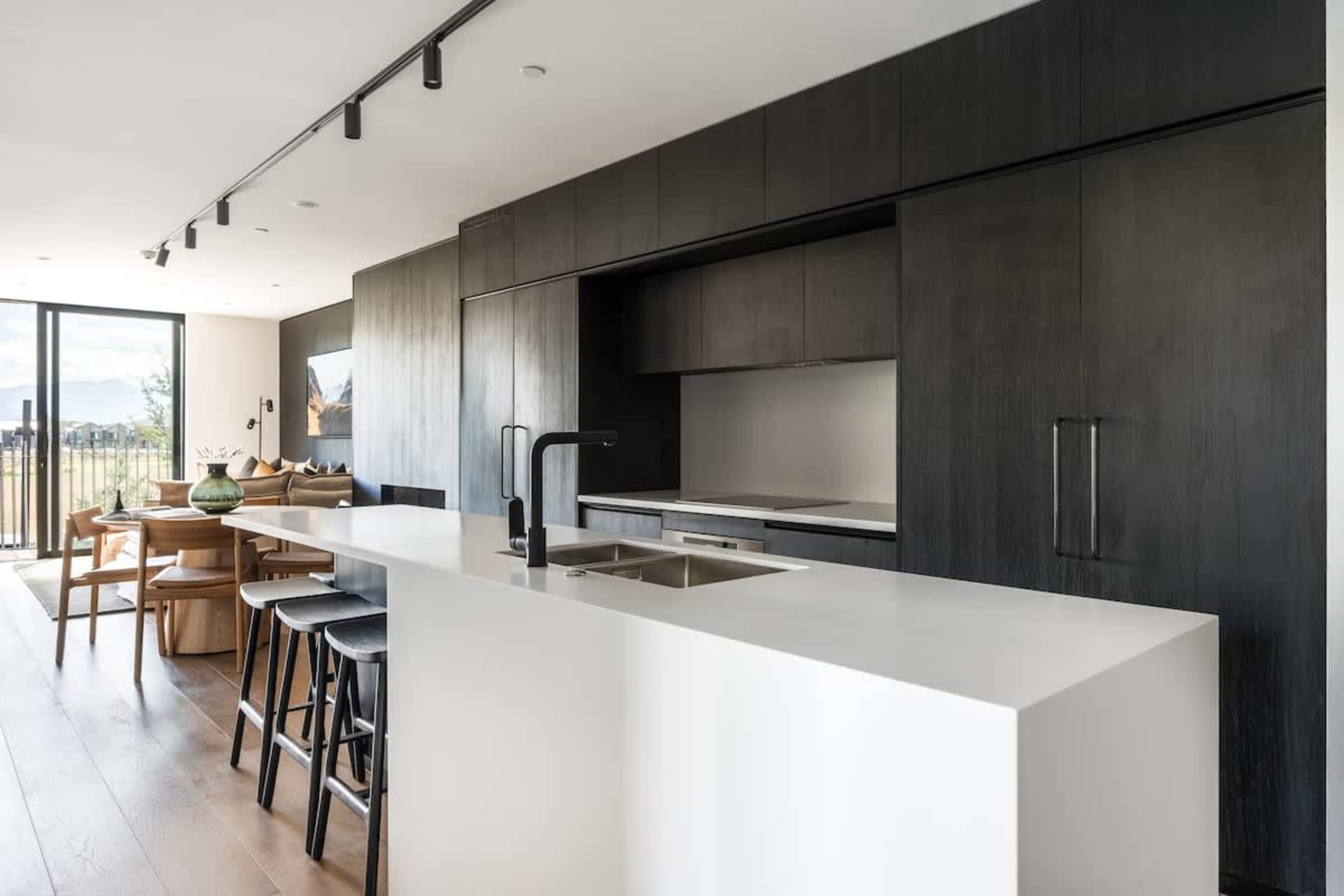Luxury modern kitchen, Clubhouse Lane apartments, Jacks Point Golf Course. Stone benchtops, high-end appliances, breakfast bar, panoramic Remarkables & Lake Tewa views. Queenstown golf & ski retreat.