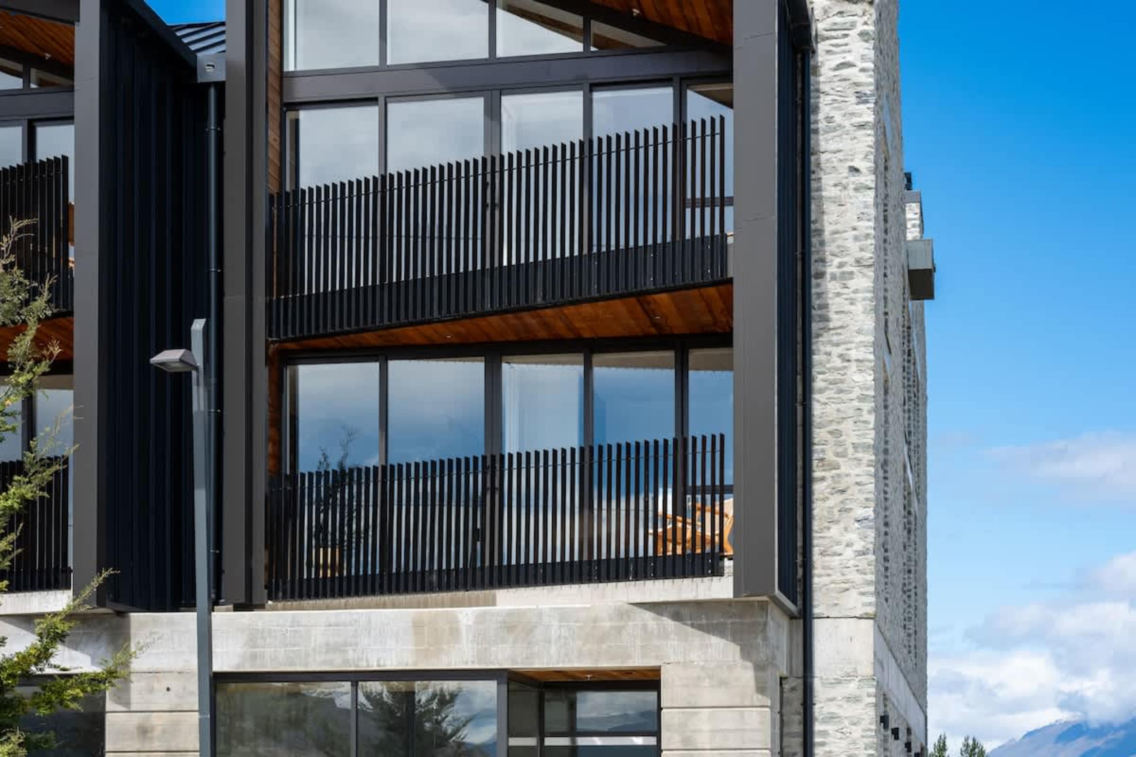 Modern alpine exterior, Clubhouse Lane at Jacks Point. Elegant design overlooking the golf course with breathtaking Remarkables mountain & Lake Tewa views. Ultimate Queenstown golf & skiing retreat.