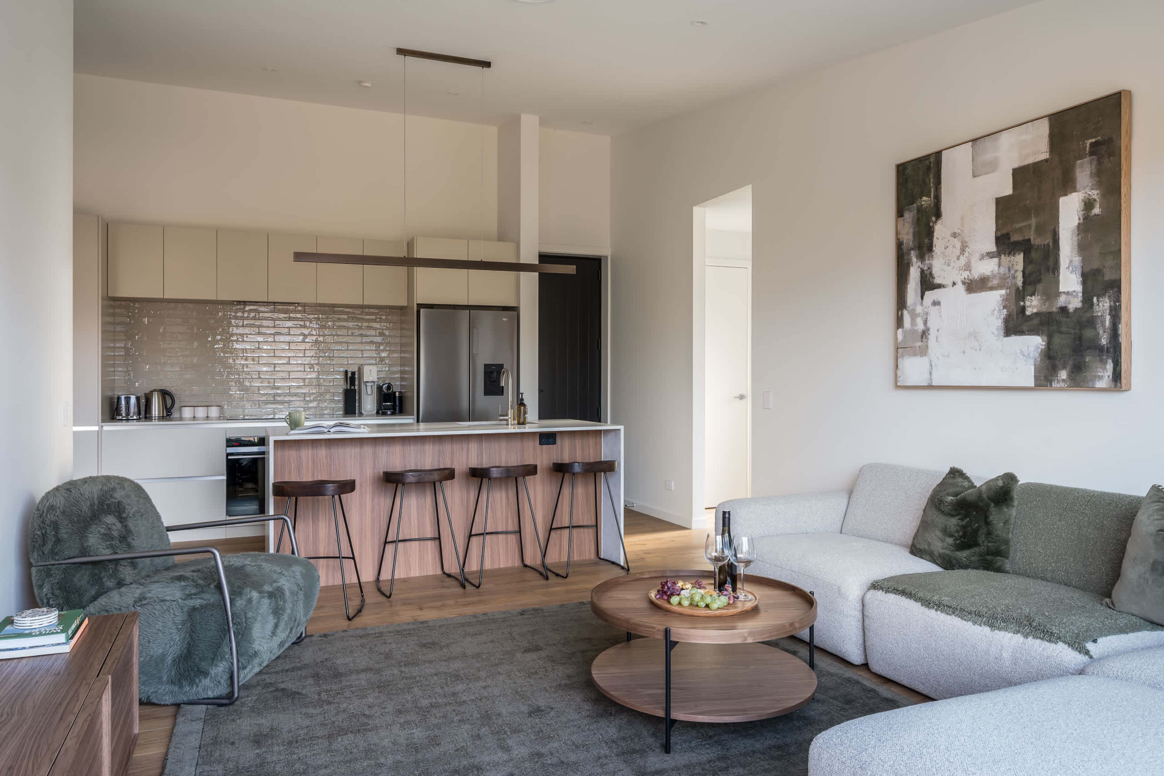 A bright, open-plan living, kitchen and dining space, beautifully finished in rich walnut and smooth stone.