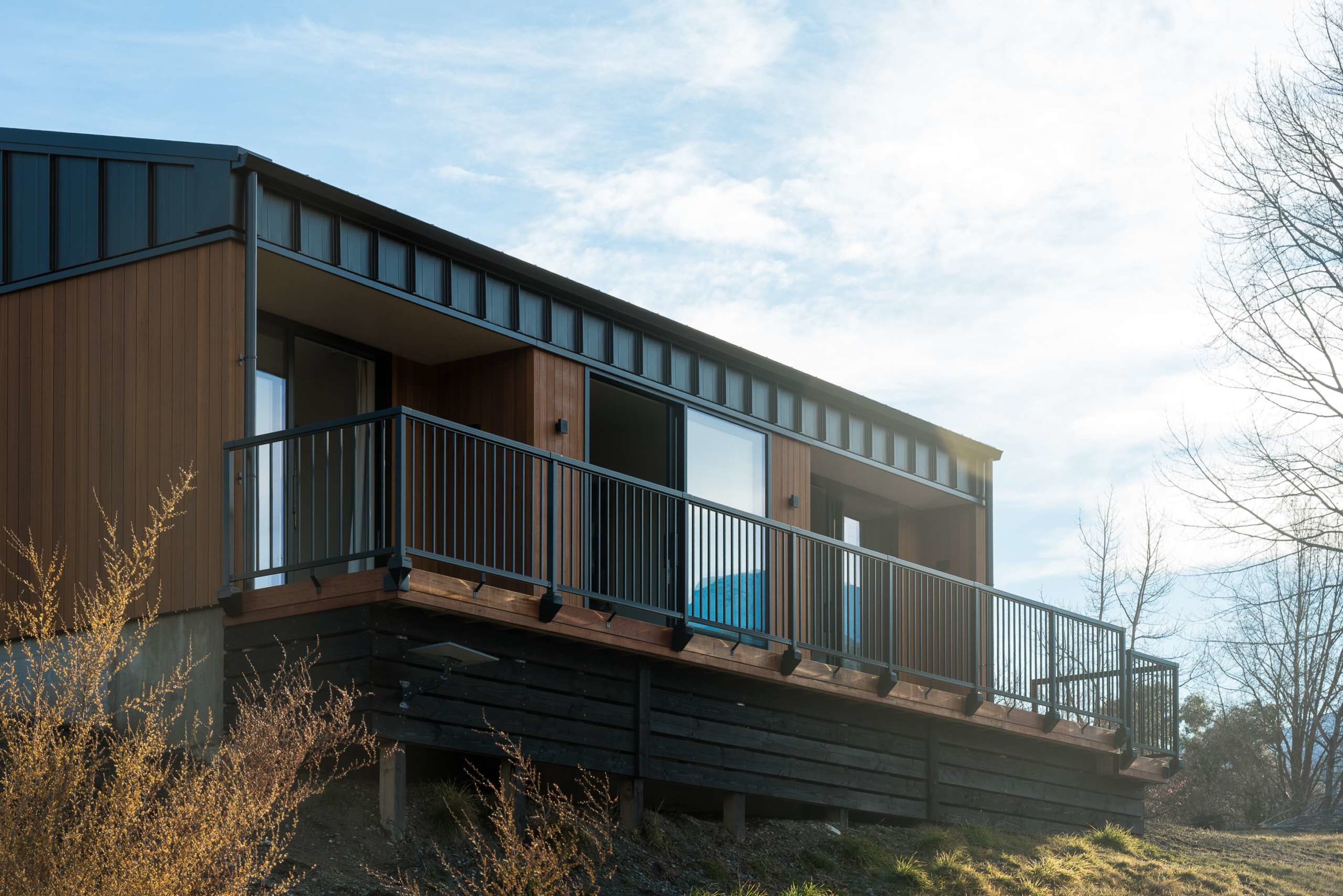 Perched high on the sunlit hillside, with the majestic Remarkables filling the horizon.