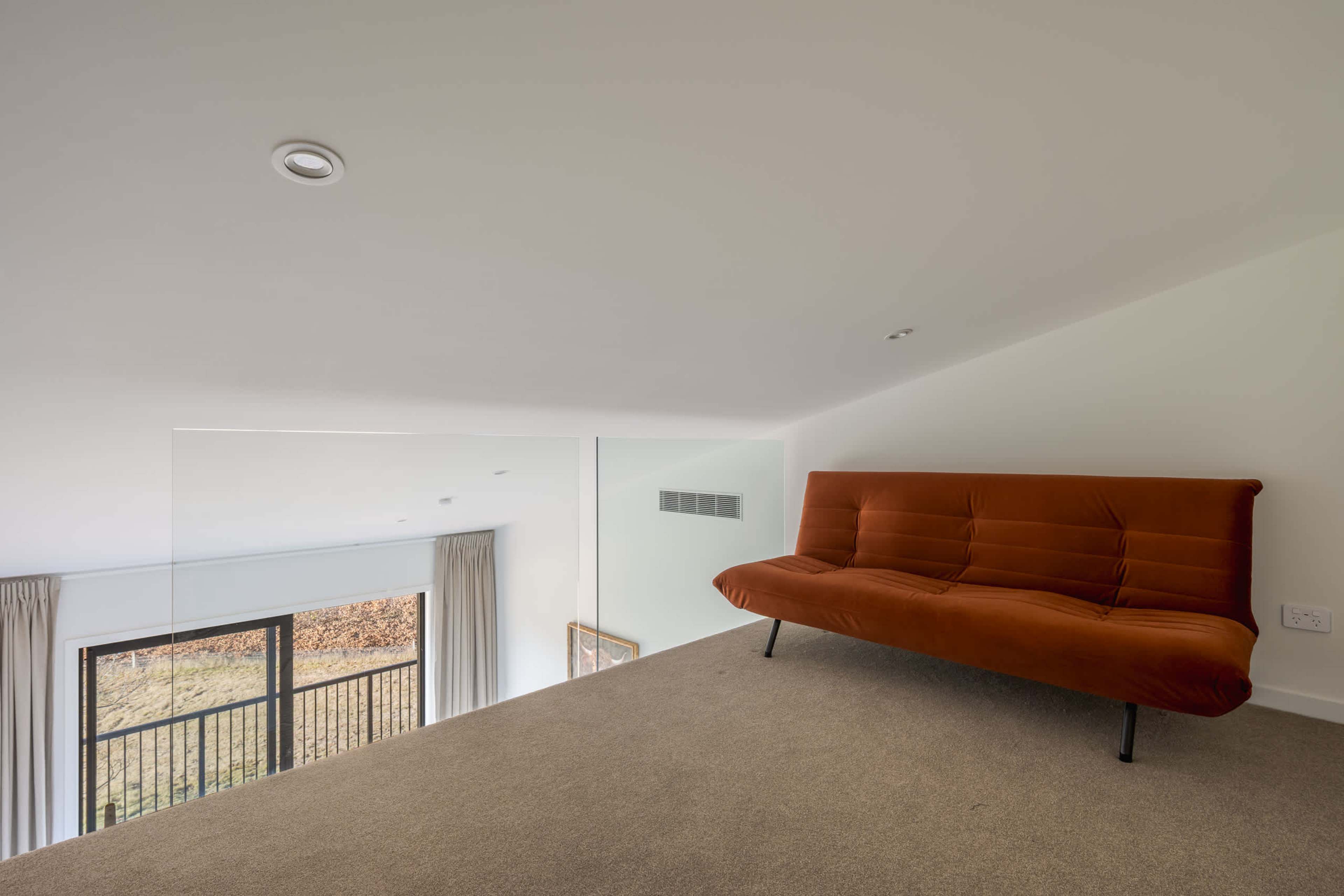 A cosy, quiet loft lounge tucked above the split king bedroom, perfect for reading or a relaxing nightcap.