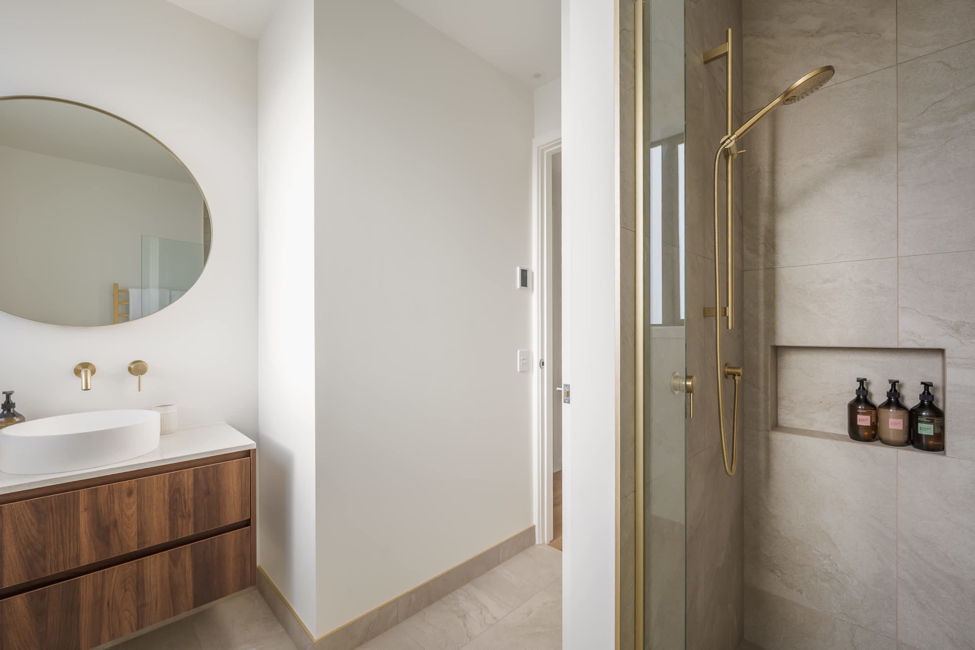 A beautifully finished vanity in rich walnut, with premium New Zealand amenities close at hand.