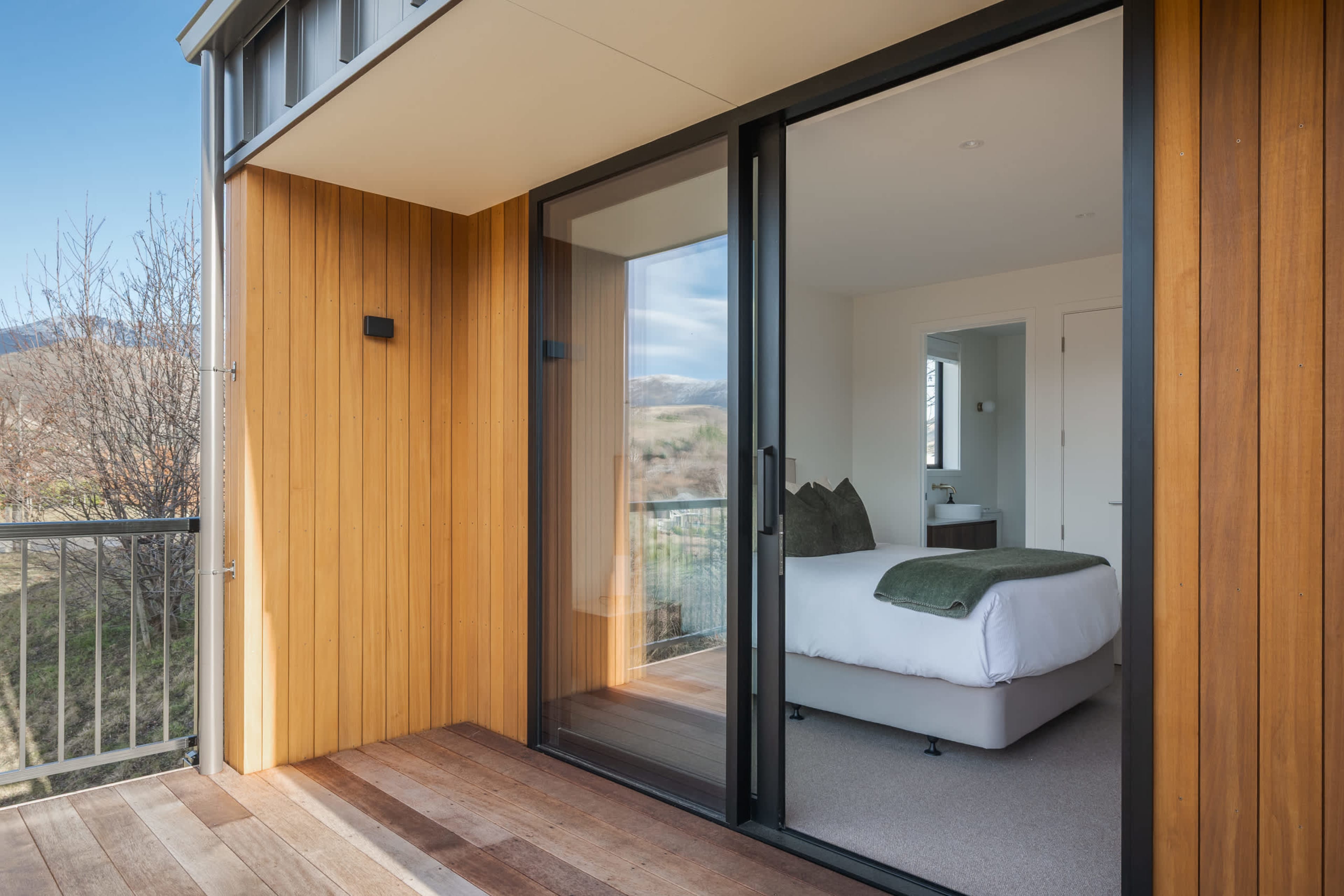 The elegant queen bedroom opens straight onto the sun-drenched deck.
