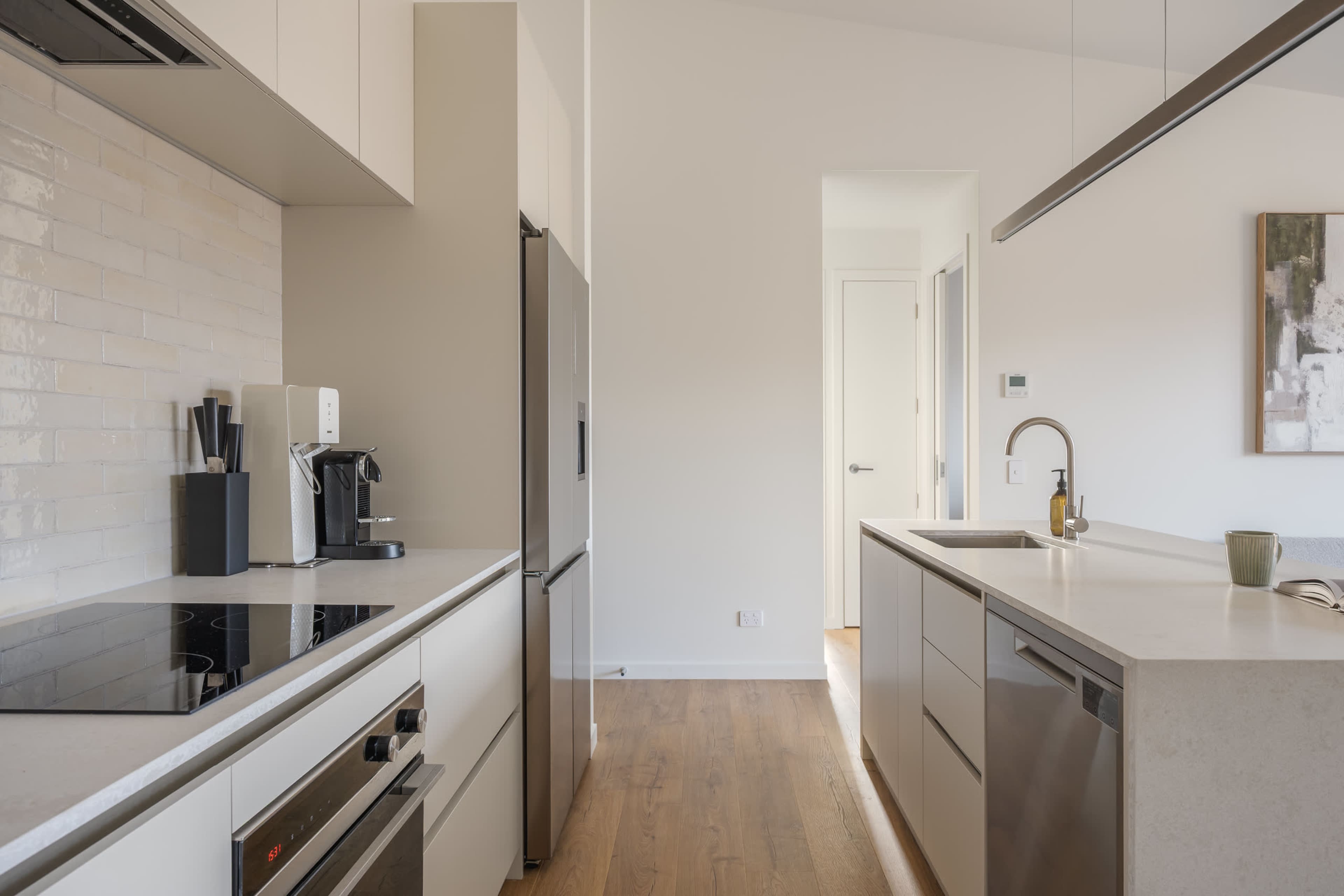 A bright, fully equipped kitchen, finished in warm neutrals and rich walnut.