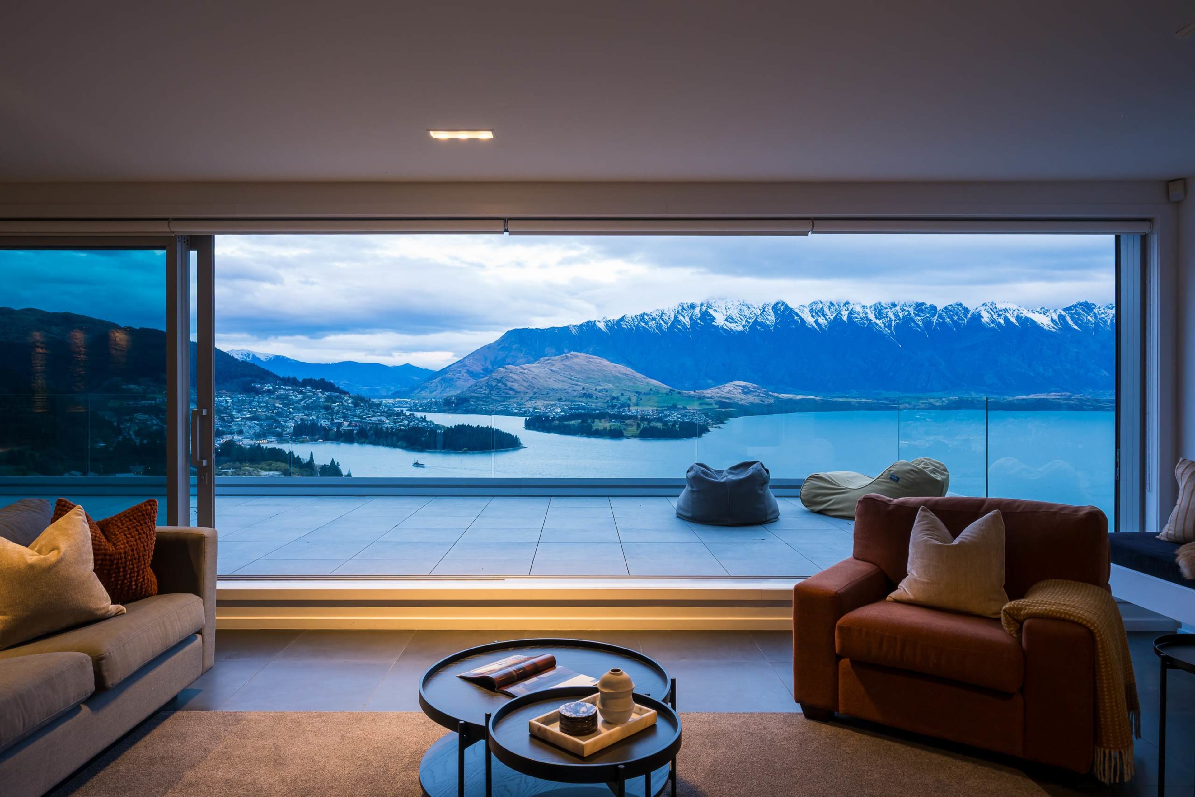 Open the glass and the lounge becomes part of the terrace. A few steps from the sofa and you’re standing at the edge of the view, with the lake in front and the mountains beyond.