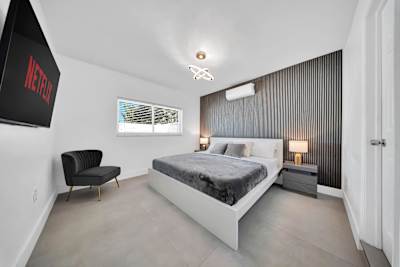 Second master suite featuring a Smart TV, lounge seating, and an ensuite bathroom