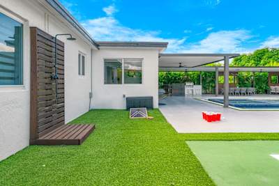 Fun-filled backyard with outdoor shower, cornhole, and XL beer pong