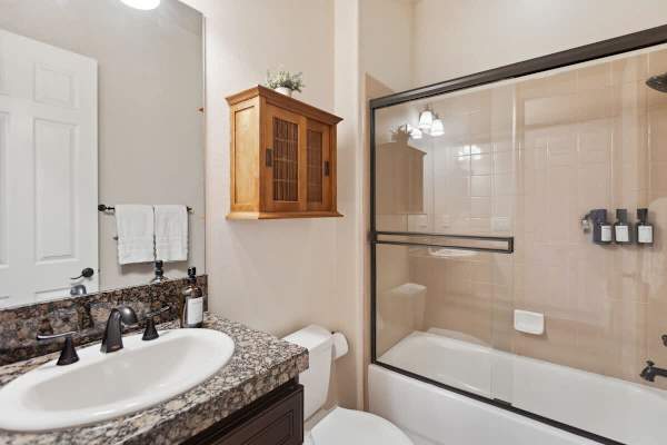 Shared bathroom with granite counters and a shower-tub combo for everyone.
