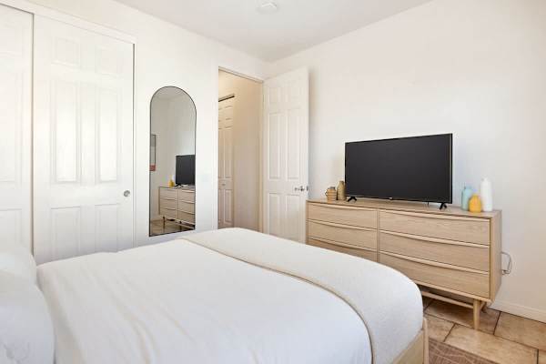 Clean and simple second bedroom with TV and dresser for convenience.