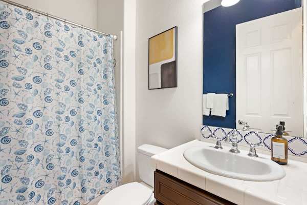 Cheerful blue accents and fresh towels make this shared bathroom feel welcoming.