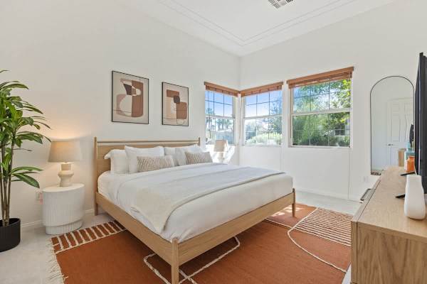 Peaceful primary bedroom with platform bed and serene mountain views beyond windows.