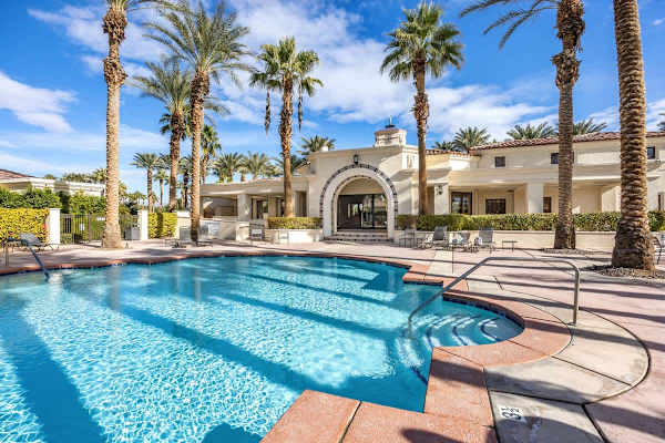 Sparkling community pool with lounge chairs and umbrellas waits for sunny afternoons.