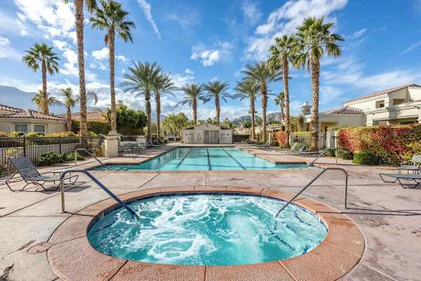 Hot tub and pool combo under blue skies offers the ultimate relaxation choice.