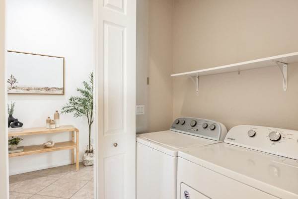 Full-size washer and dryer plus storage shelves keep things organized and simple.