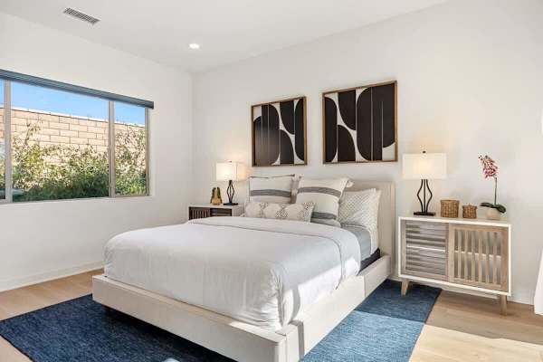 Crisp white bedding and coastal vibes—sleep soundly in this peaceful primary bedroom.