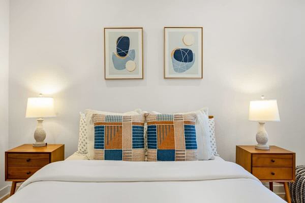 Coastal prints above mid-century nightstands.