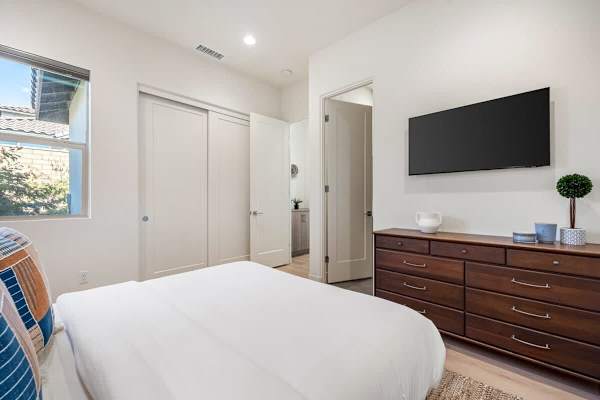 Guest bedroom with wall-mounted TV.