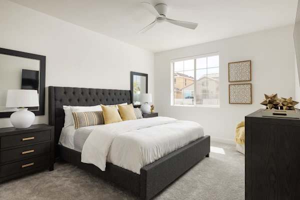 Dark wood bed frame anchors this bright retreat.