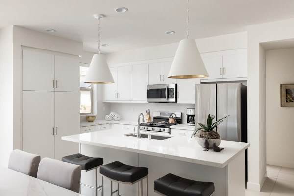 All-white modern kitchen with breakfast bar.