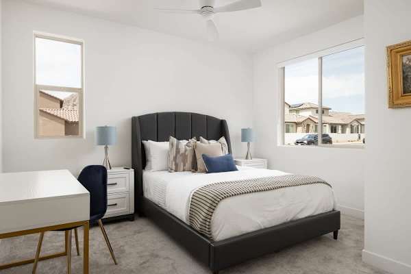 Guest bedroom with tufted frame—blue and gray tones create a restful second retreat.