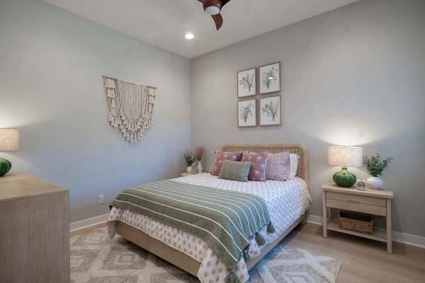 Bedroom with botanical gallery wall—soft blues and natural textures.