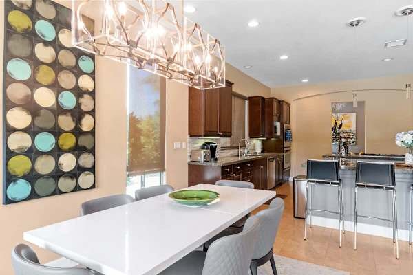 White dining table with colorful wall art.