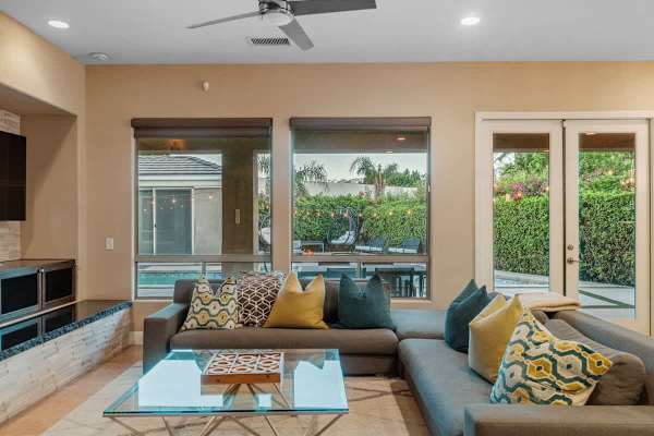 Windows erase the barrier—pool and palms become part of your living room experience.