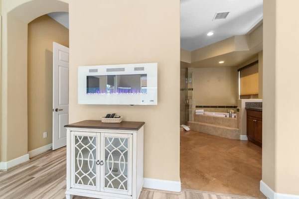 White cabinet console leads to primary bath—clean lines and natural light define this retreat.