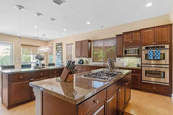 Granite island with wood cabinetry—ready for home cooking.