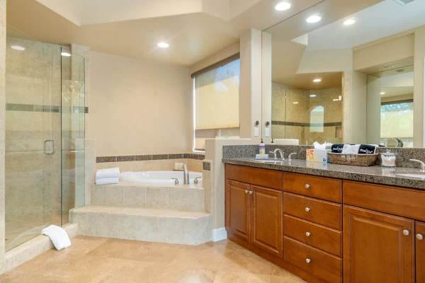 Wood cabinetry and dual sinks complete this spa-worthy primary bath.