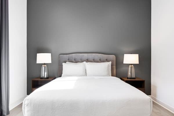 Clean white linens and gray accent wall.