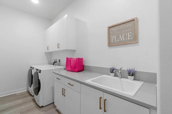 Dual sinks in laundry room plus washer-dryer.