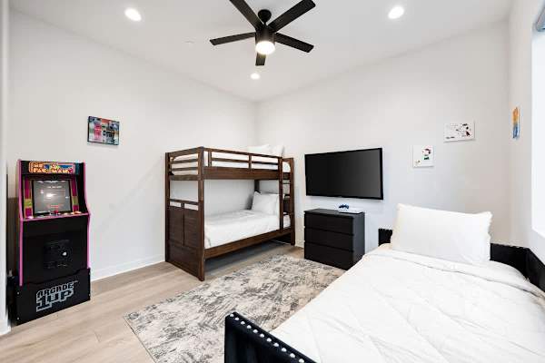 Bunk beds plus single bed with arcade game.