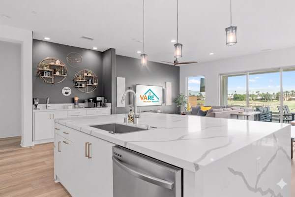 Quartz island with coffee bar—gray accent wall and round mirrors.
