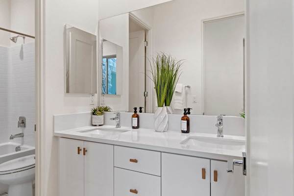 Shared bath with dual sinks and subway tile—clean white finishes serve bedrooms two and three.