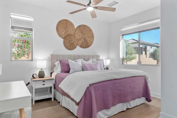 Woven wall art and dual windows brighten this guest room.