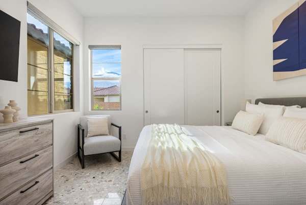 Peaceful bedroom with plush bedding and seating area for quiet downtime moments.
