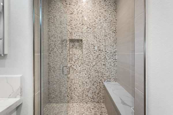 Walk-in shower with beautiful tile work makes getting ready feel like a spa experience.