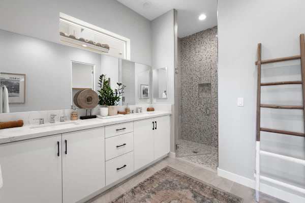 Spacious bathroom features double vanity, walk-in shower, and plenty of natural light.