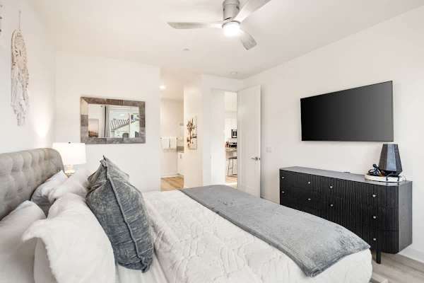 King bedroom features ceiling fan, TV, and plenty of dresser.