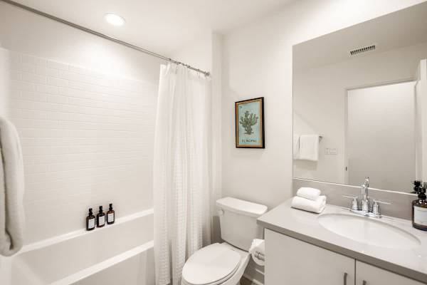 Full bathroom with tub and fresh towels serves the secondary bedrooms on the main floor.