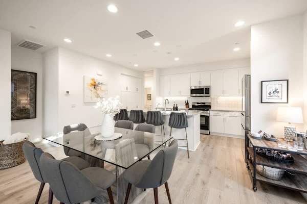Dining table seats six comfortably with views into the kitchen.